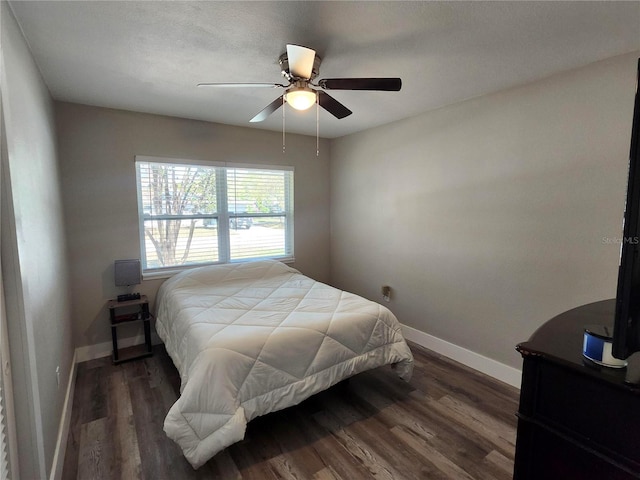 bedroom with a ceiling fan, baseboards, and wood finished floors