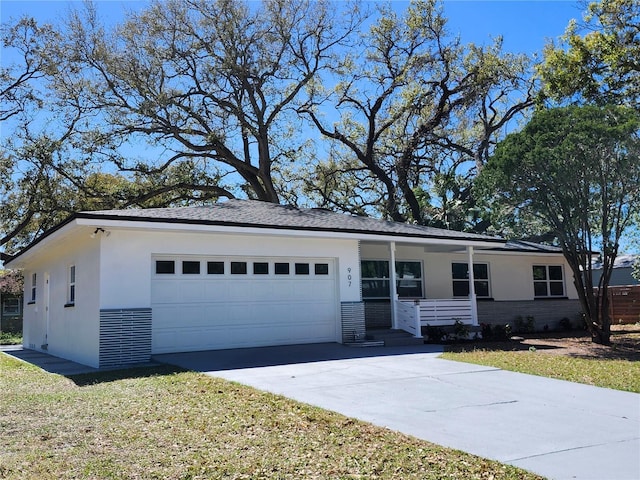 view of front of home featuring stucco siding, concrete driveway, covered porch, an attached garage, and a front yard