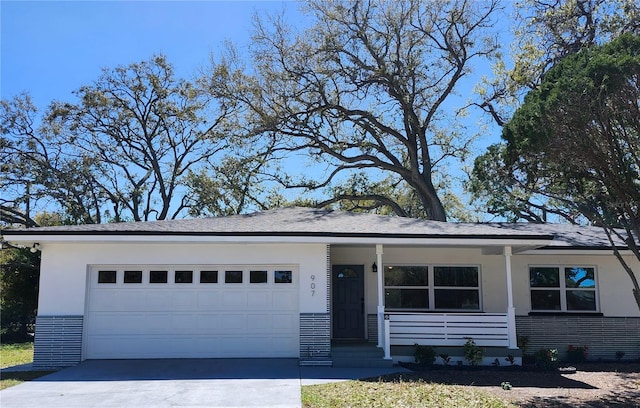 single story home featuring driveway, a porch, an attached garage, and stucco siding