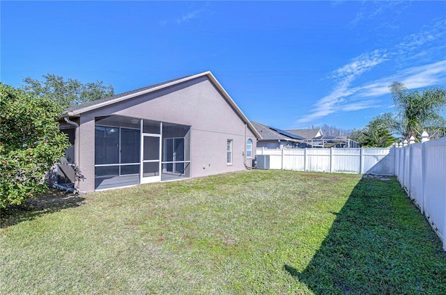 view of yard with a sunroom, a fenced backyard, and central AC unit