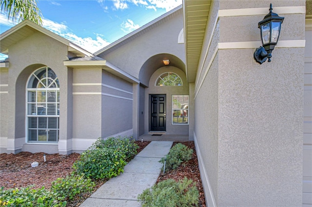 doorway to property featuring stucco siding