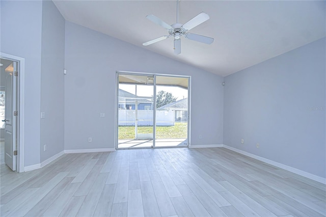 empty room featuring lofted ceiling, ceiling fan, light wood-style flooring, and baseboards