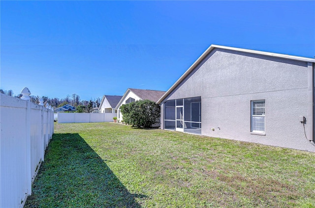 view of yard with a fenced backyard and a sunroom