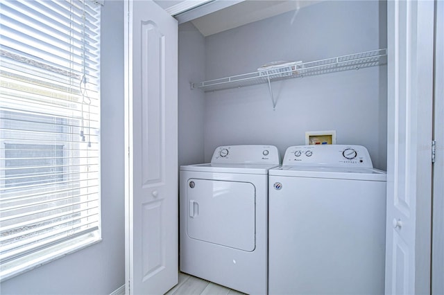 laundry room with a wealth of natural light, laundry area, and washer and clothes dryer