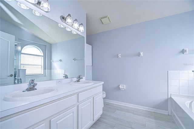 full bath featuring vaulted ceiling, visible vents, a sink, and toilet