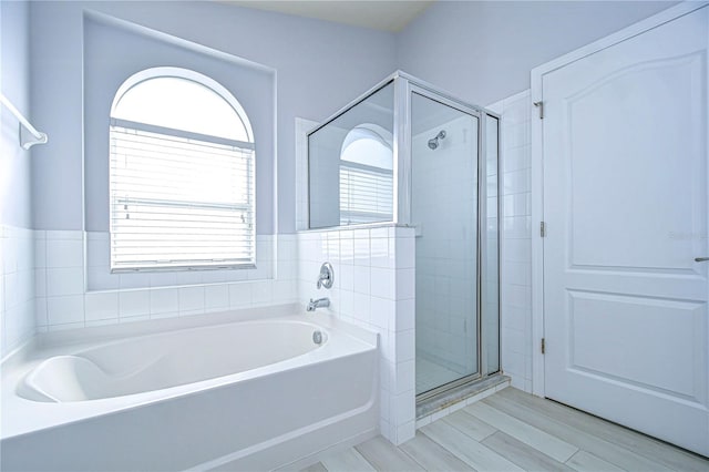 bathroom featuring a garden tub and a shower stall