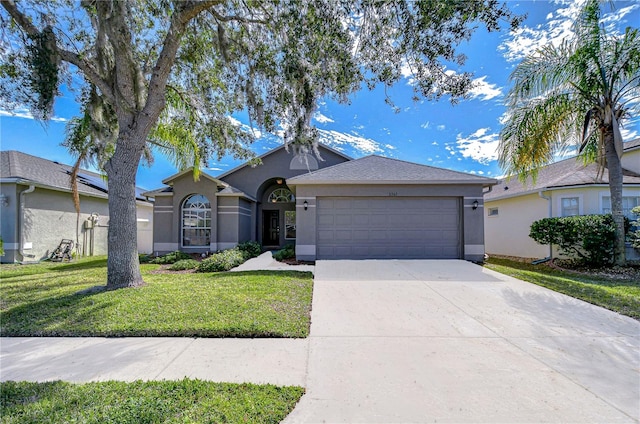 ranch-style home with a garage, concrete driveway, a front lawn, and stucco siding