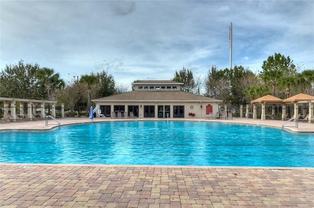 pool with a patio area and fence