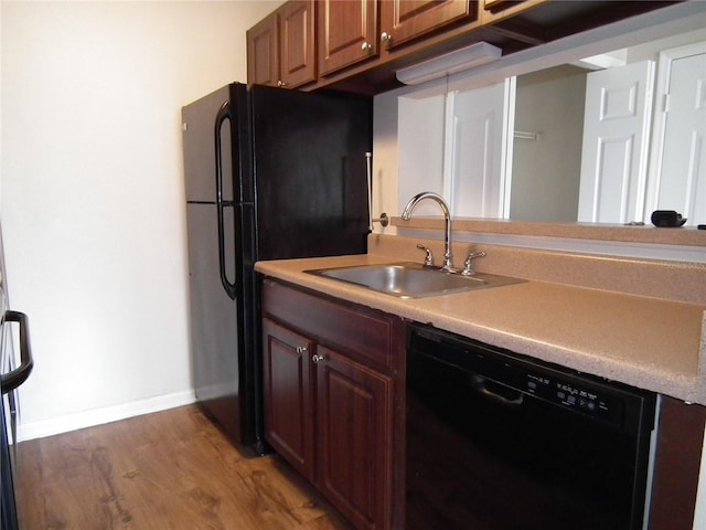 kitchen with sink, dark wood-type flooring, and black appliances