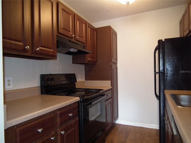 kitchen featuring tasteful backsplash, dark hardwood / wood-style floors, a textured ceiling, and black appliances