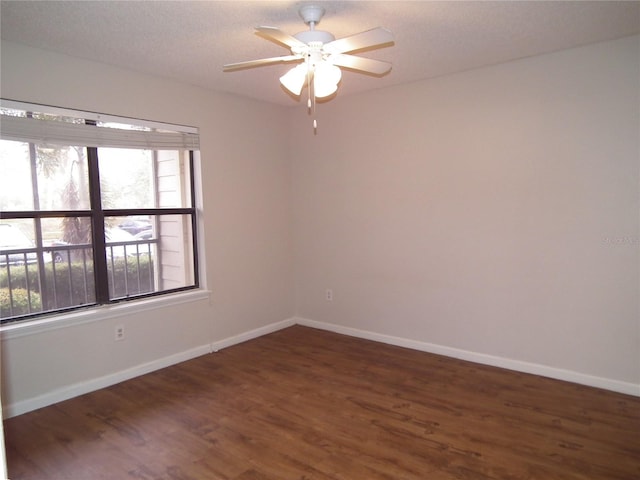 spare room with ceiling fan, dark hardwood / wood-style flooring, and a wealth of natural light