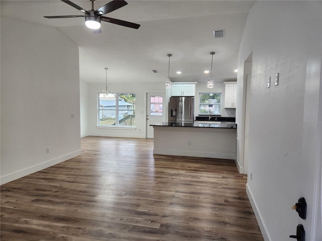 unfurnished living room featuring sink, vaulted ceiling, ceiling fan with notable chandelier, and dark hardwood / wood-style floors