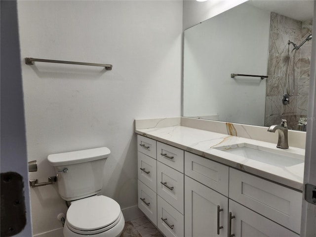 bathroom featuring a tile shower, toilet, and vanity