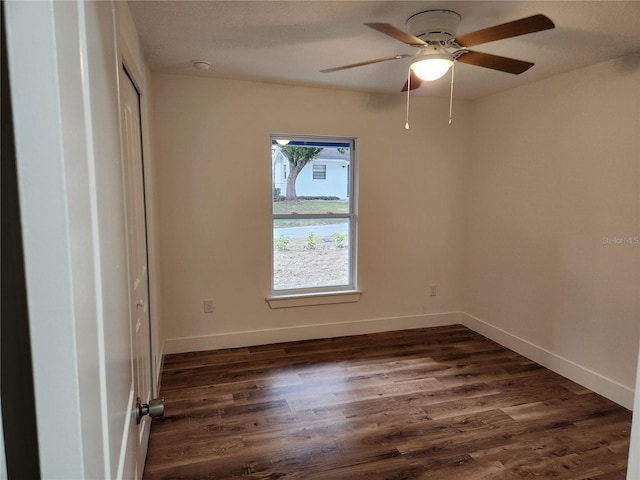 spare room with dark hardwood / wood-style floors and ceiling fan