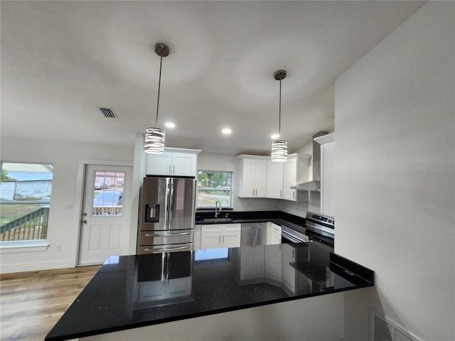 kitchen featuring pendant lighting, white cabinets, stainless steel appliances, light hardwood / wood-style floors, and sink