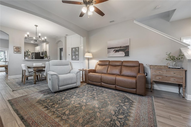 living room with plenty of natural light and ceiling fan with notable chandelier