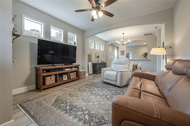 living room with ceiling fan with notable chandelier