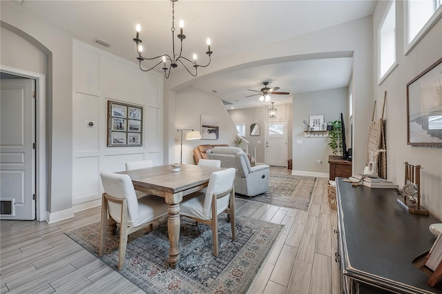 dining area with ceiling fan with notable chandelier