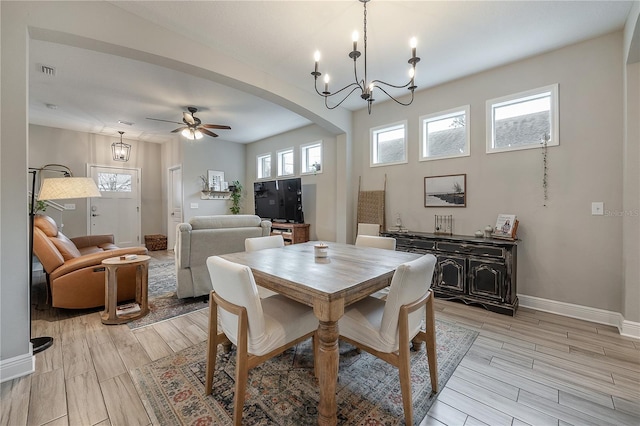 dining area featuring ceiling fan with notable chandelier