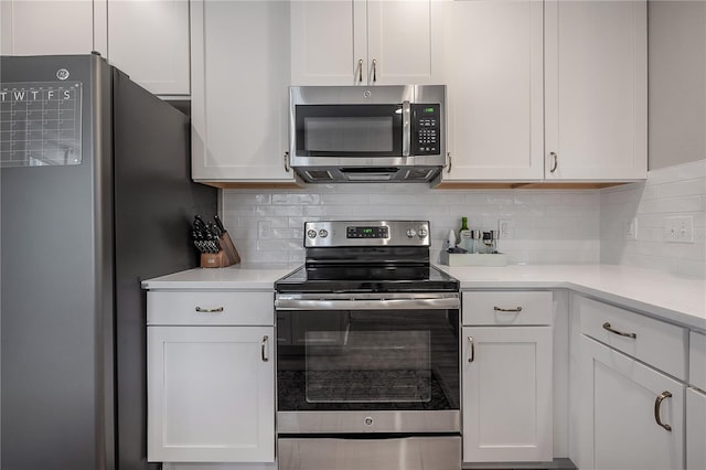 kitchen featuring stainless steel appliances, white cabinetry, and decorative backsplash