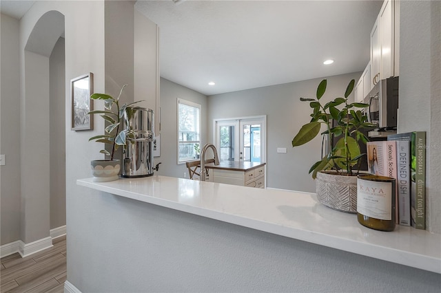 kitchen featuring white cabinets, kitchen peninsula, and sink