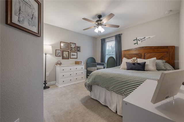 bedroom with ceiling fan and light carpet