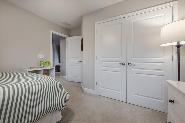 bedroom featuring light carpet and a closet