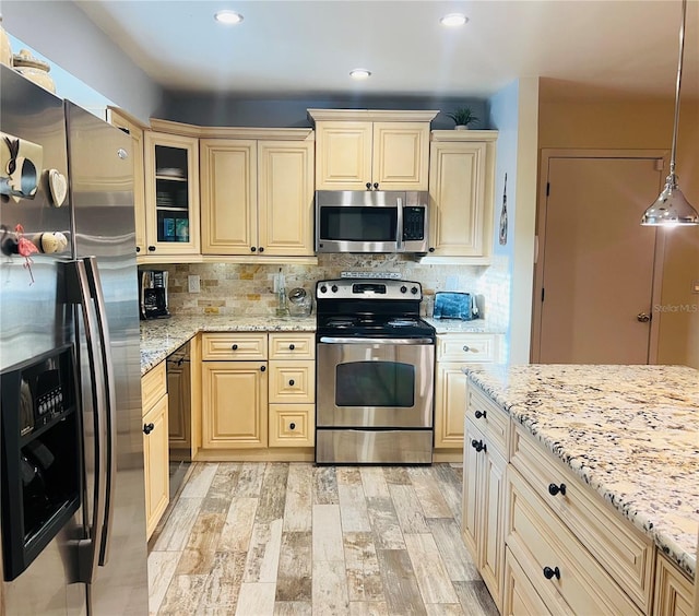 kitchen with decorative light fixtures, light hardwood / wood-style floors, decorative backsplash, and appliances with stainless steel finishes