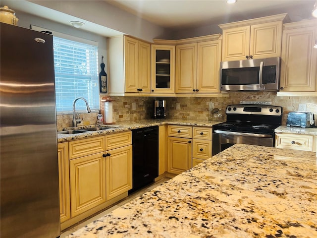 kitchen featuring sink, light stone counters, tasteful backsplash, and stainless steel appliances