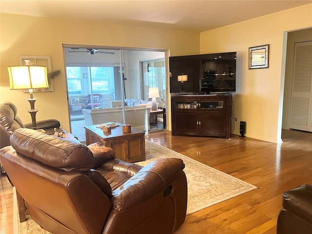 living room with ceiling fan and light hardwood / wood-style flooring