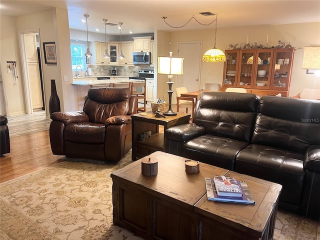 living room featuring light hardwood / wood-style floors and sink