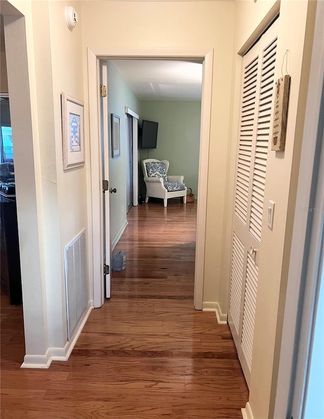 corridor with dark hardwood / wood-style flooring