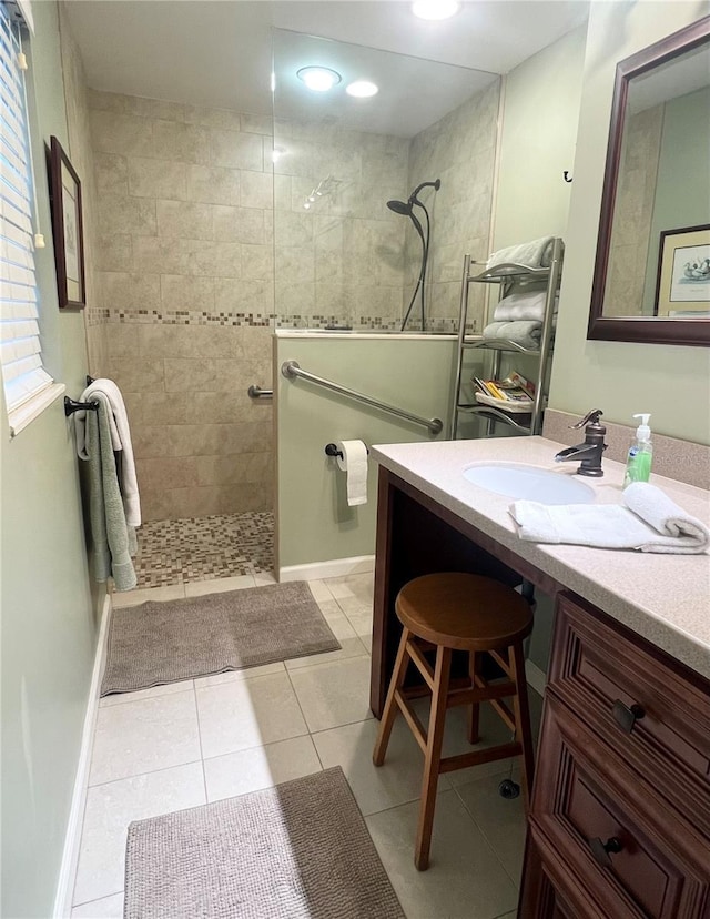 bathroom featuring tiled shower, tile patterned flooring, and vanity