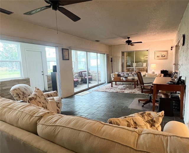 living room featuring a textured ceiling and ceiling fan