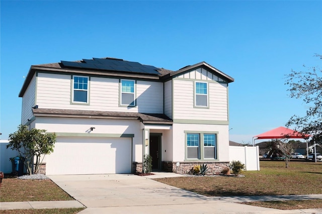 view of front of property featuring a garage, a front lawn, and solar panels