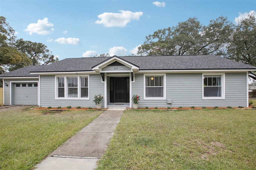 single story home with a garage and a front lawn