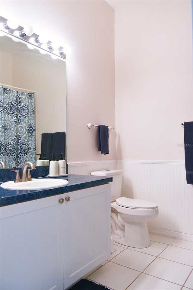 bathroom featuring tile patterned flooring, vanity, and toilet