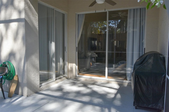 view of exterior entry with a patio and ceiling fan