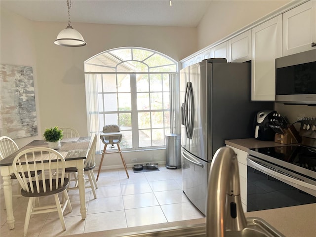 kitchen featuring white cabinetry, a wealth of natural light, electric range oven, and pendant lighting