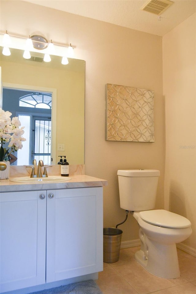 bathroom with tile patterned flooring, vanity, and toilet