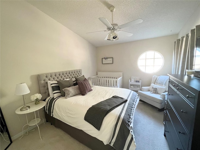 bedroom with carpet, a textured ceiling, and ceiling fan