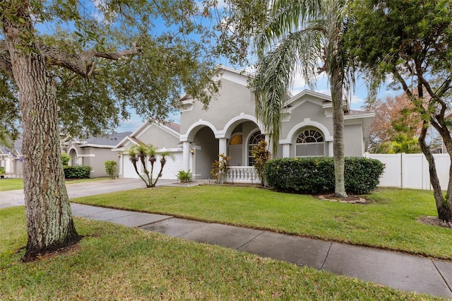 mediterranean / spanish-style house with a garage and a front lawn