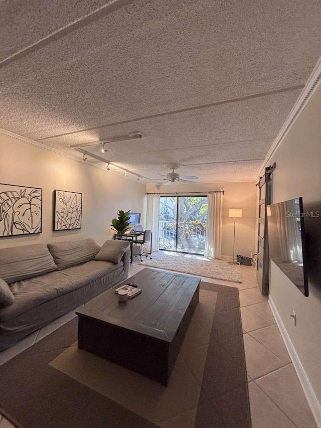 tiled living room with track lighting, a barn door, ornamental molding, and a textured ceiling