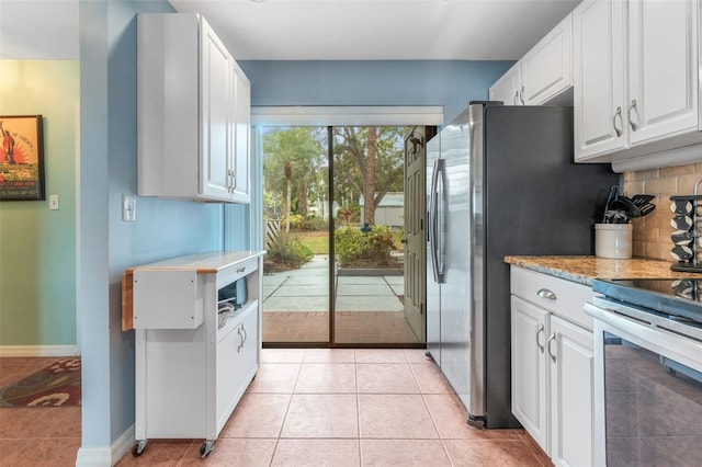 kitchen featuring decorative backsplash, light tile patterned floors, white cabinets, and stainless steel electric range oven