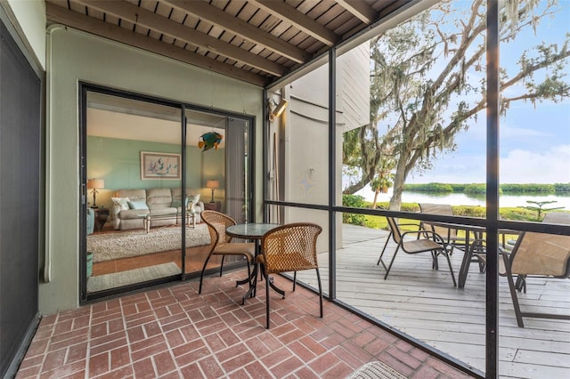 sunroom / solarium featuring a water view, beamed ceiling, and wooden ceiling