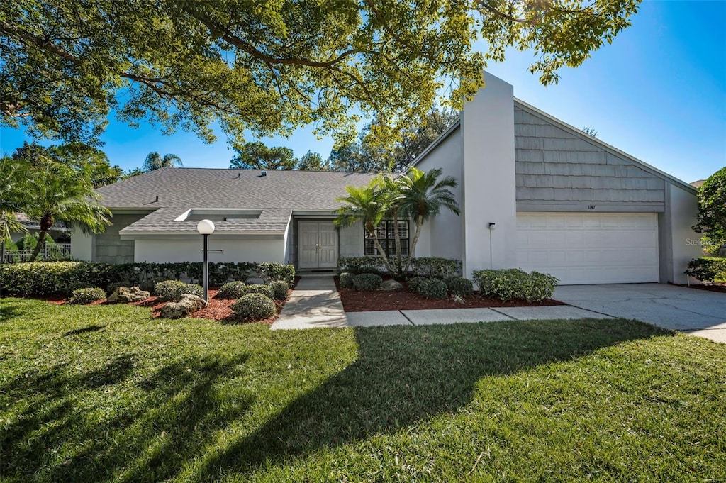 ranch-style house featuring a garage and a front yard