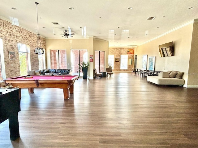 playroom with hardwood / wood-style flooring, brick wall, and ornamental molding