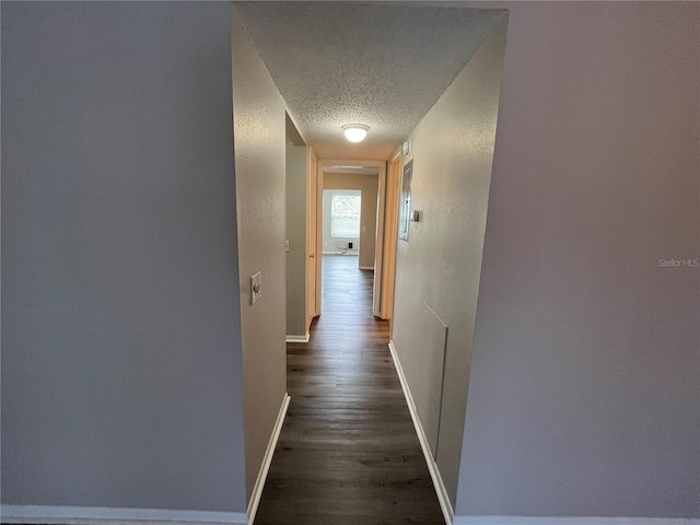 hall featuring dark hardwood / wood-style flooring and a textured ceiling