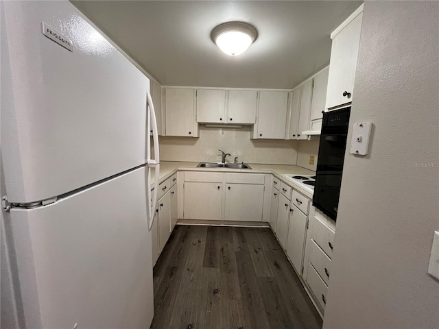 kitchen with sink, white cabinets, dark hardwood / wood-style floors, and white refrigerator