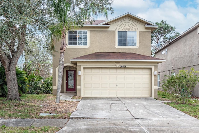 traditional home featuring stucco siding, driveway, and an attached garage